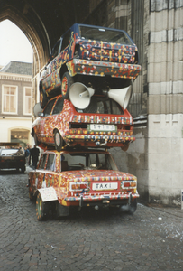 605819 Afbeelding van drie op elkaar gestapelde auto's in een carnavalsoptocht in de onderdoorgang van de Domtoren te ...